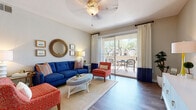 Located at 1889 W Queen Creek Rd in Chandler, Arizona, this well-appointed single-floor residence offers a thoughtfully designed layout with comfortable living spaces and modern finishes throughout. The open-concept living room is a welcoming centerpiece, featuring wood-style flooring, a ceiling fan, and large sliding glass doors that flood the space with natural light and provide direct access to a private balcony overlooking lush desert landscaping. The kitchen is equipped with stainless steel appliances, white cabinetry, dark countertops, and a breakfast bar that connects seamlessly to the dining area. The dining space accommodates a round table with ample room, complemented by pendant lighting overhead. Two well-sized bedrooms offer plush carpeting, ceiling fans, and generous windows that bring in natural light. The primary bathroom features white shaker-style cabinetry, a wide vanity with a neutral stone-toned countertop, and a large mirror. Throughout the residence, a cohesive design aesthetic ties each space together, blending functionality with comfort. The private balcony, framed by views of mature trees and the surrounding Chandler community, adds an inviting outdoor retreat to this well-rounded home.
