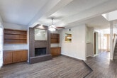 Located at 509 Delmar St in Midland, Texas, this two-story home offers a well-organized layout across two levels, combining functional design with comfortable living spaces. The main level features wood-look flooring that flows through the living and dining areas, complemented by a textured ceiling finish. A pass-through window connects the kitchen to the main living space, enhancing the open feel. The kitchen is equipped with rich wood cabinetry, a double-basin stainless steel sink, a coil-burner electric range, and tile flooring. Natural light fills the living area through French doors, which are fitted with blinds and topped with a ceiling fan. A carpeted staircase leads to the upper level, where the bedrooms are finished with plush carpet and ceiling fans. The primary bedroom includes mirrored sliding closet doors flanked by open shelving on both sides, providing ample storage. Additional bedrooms feature windows with blinds, allowing natural light to filter in. The bathrooms include a tub-shower combination with white square tile surround and chrome fixtures, as well as a vanity with a single-basin undermount sink and a large mirror. Throughout the home, neutral tones and consistent finishes create a cohesive and move-in ready environment.