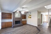 Located at 509 Delmar St in Midland, Texas, this two-story home offers a well-organized layout across two levels, combining functional design with comfortable living spaces. The main level features wood-look flooring that flows through the living and dining areas, complemented by a textured ceiling finish. A pass-through window connects the kitchen to the main living space, enhancing the open feel. The kitchen is equipped with rich wood cabinetry, a double-basin stainless steel sink, a coil-burner electric range, and tile flooring. Natural light fills the living area through French doors, which are fitted with blinds and topped with a ceiling fan. A carpeted staircase leads to the upper level, where the bedrooms are finished with plush carpet and ceiling fans. The primary bedroom includes mirrored sliding closet doors flanked by open shelving on both sides, providing ample storage. Additional bedrooms feature windows with blinds, allowing natural light to filter in. The bathrooms include a tub-shower combination with white square tile surround and chrome fixtures, as well as a vanity with a single-basin undermount sink and a large mirror. Throughout the home, neutral tones and consistent finishes create a cohesive and move-in ready environment.