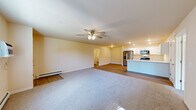 Located at 4395 Christopher Dr in Eau Claire, Wisconsin, this single-floor, 2-bedroom, 2-bathroom home offers a well-designed, functional layout. The open-concept living and kitchen area serves as the heart of the home, where plush carpeting in the living room transitions to durable wood-look flooring in the kitchen. The kitchen is appointed with crisp white shaker-style cabinetry, a full suite of stainless steel appliances including a French door refrigerator, electric range, and over-the-range microwave, complemented by a central island and recessed lighting. A ceiling fan with light kit keeps the living area comfortable year-round, alongside a baseboard heating system. Both bedrooms are generously sized, featuring soft carpeting, ceiling fans, natural light from windows with outdoor views, and baseboard heaters with wall-mounted AC units. The spacious primary bedroom includes a walk-in closet outfitted with wire shelving. The primary bathroom features wood-look flooring, white cabinetry with ample storage, a wide vanity with a single sink, and a full-height linen cabinet. A hallway connects the bedrooms and bathrooms, completing this practical and well-appointed single-level home.