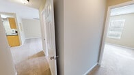 Located at 505 Fox Crossing Blvd in Knoxville, Tennessee, this single-floor, four-bedroom, two-bathroom home offers a practical and comfortable layout. The combined kitchen and living area serves as the heart of the home. The kitchen features a galley-style design with light wood cabinetry, dark granite countertops, tile flooring, and black appliances including a range, microwave, and refrigerator. A chandelier illuminates the adjacent living area, which is finished with neutral carpet and opens to the exterior through a set of French doors. A ceiling fan adds to the comfort of the space. The four bedrooms are carpeted throughout and finished with warm neutral tones, white six-panel doors, and clean white baseboards. The spacious primary bedroom includes a walk-in closet equipped with wire shelving and hanging rods. The bathrooms feature tub-shower combinations with chrome fixtures. A dedicated laundry room includes washer hookups, wire shelving, and a utility drain. The hallway connects all rooms efficiently within the single-story footprint. Overall, the home presents a clean, functional design with consistent finishes throughout.