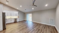 Located at 116 Starlight Walk in Holbrook, NY, this thoughtfully designed single-floor residence combines modern finishes with a clean, neutral aesthetic. Hardwood-style flooring flows seamlessly throughout the home, complementing the warm gray tones that define each room.

The open-concept living and kitchen area is bright and welcoming, featuring recessed lighting, a ceiling fan, and sliding glass doors that invite natural light and provide access to the outdoors. The kitchen is well-appointed with white shaker cabinetry, quartz countertops, a marble-style backsplash, stainless steel appliances including a gas range, microwave, and dishwasher, and a undermount sink — offering both style and functionality.

The bedrooms feature vaulted ceilings that enhance the sense of space, along with generous closet storage. One bedroom includes a custom-organized closet with built-in shelving and drawers, while another offers a standard reach-in closet. Dual windows in the main bedroom frame neighborhood views and flood the room with natural light.

The bathroom is elegantly finished with marble-look tile on the walls and a mosaic tile floor, complemented by a frameless sliding glass shower enclosure over a soaking tub and gold-toned hardware. Every detail of this home reflects quality craftsmanship and modern design sensibility.