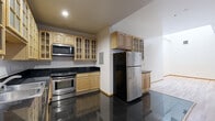 Located in the heart of Downtown Los Angeles, this 1-bedroom, 2-bathroom residence offers a thoughtfully designed single-floor layout with a mix of modern finishes and architectural character. The kitchen is a standout feature, showcasing polished black granite countertops, light natural wood cabinetry with glass-front upper panels, and a full suite of stainless steel appliances, all set atop gleaming dark tile flooring. The layout flows seamlessly from the kitchen into the living areas, where warm hardwood flooring extends throughout. The spacious primary bedroom benefits from a skylight that floods the room with natural light, complemented by large windows overlooking an adjacent brick facade, adding an urban character to the space. Rich dark wood-framed mirrored closet doors and transom windows add refined detail. Both bathrooms feature tub-shower combinations with elegant cream marble-style tile surrounds and coordinating tile flooring, with one bathroom offering a dark granite vanity countertop. Ceilings throughout the unit are notably tall, enhancing the open, airy feel of every room. The overall ambiance balances urban sophistication with comfortable, livable design in one of Downtown LA's well-established addresses.