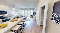 Located at 125 Prairie Pkwy in Katy, TX, this thoughtfully designed 720-square-foot, one-bedroom, one-bathroom apartment offers a efficient and modern single-floor layout. The open-concept kitchen and living area serves as the heart of the unit, featuring a sleek white kitchen with shaker-style cabinetry, a tile backsplash, stainless steel appliances, and a large center island with pendant lighting and bar seating for four — ideal for both cooking and casual dining. Light wood-style flooring flows seamlessly throughout the unit. The living room is bright and airy, with large windows and a glass-panel door that flood the space with natural light, complemented by a ceiling fan overhead. The 170-square-foot primary bedroom offers a calm, neutral palette, a ceiling fan, and generous natural light from a large window with sheer curtains. A dedicated closet provides organized storage. The bathroom features a white vanity with quartz countertop, ample cabinetry, a lighted mirror, and a glass-enclosed walk-in shower with marble-style tile surround. Clean lines and neutral tones create a cohesive, contemporary ambiance throughout this well-appointed Katy, TX residence.