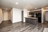 This two-story home offers a well-organized layout across two floors, with four bedrooms and three bathrooms designed for comfortable everyday living. The main floor features an open-concept kitchen and living area with durable wood-look vinyl plank flooring throughout. The kitchen is equipped with dark-toned cabinetry, a black appliance suite including a full-size refrigerator and range, a double-basin sink, and a peninsula that opens to the living space. The living room is highlighted by a ceiling fan, a sliding glass door that fills the area with natural light and provides access to the outdoors, and a staircase leading to the upper level. A half bathroom is also conveniently located on the main floor. Upstairs, the larger floor area houses all four bedrooms, including the primary bedroom with a walk-in closet featuring wire shelving on multiple walls. The upper-level bedrooms are carpeted and include windows that bring in natural light with neighborhood views. Two full bathrooms serve the upper floor, each featuring a vanity with a light countertop, dark cabinetry, wood-look flooring, and tub-shower combinations. Two hallways connect the upper-level rooms, and textured ceilings are consistent throughout the home.