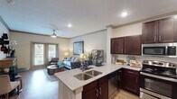 This single-level, two-bedroom, two-bathroom residence in Magnolia, Texas offers a thoughtfully designed open-concept layout with modern finishes throughout. The kitchen is a standout feature, equipped with rich dark-wood cabinetry, granite countertops, stainless steel appliances including a side-by-side refrigerator with ice maker, a built-in microwave, and an electric range. A peninsula with a double-basin sink seamlessly connects the kitchen to the living area, making it ideal for entertaining. Wood-look flooring runs throughout the main living spaces, complemented by crown molding that adds a refined touch.

The living room is bright and inviting, featuring a ceiling fan, recessed lighting, and glass doors that open to a private balcony with outdoor views. Both bedrooms are carpeted and include ceiling fans, with the primary bedroom offering generous closet space. The primary bathroom features dual vanities with granite countertops, dark cabinetry, and a well-lit mirror. The second bathroom includes a glass-enclosed shower and a single vanity with matching granite finishes. The entryway provides additional closet storage, rounding out a functional and comfortable floor plan.