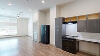 Located at 325 E Duval St in downtown Jacksonville, FL, this single-floor, one-bedroom, one-bathroom unit offers a thoughtfully designed layout that maximizes both function and comfort. Light wood-tone flooring runs throughout, complementing the neutral palette of crisp white walls and modern finishes.

The open-concept living and dining area is bright and spacious, anchored by a ceiling fan and large windows that invite natural light. This space flows directly into a well-equipped kitchen featuring dark wood-grain cabinetry with upper glass-panel accents, light countertops, and a full suite of black appliances including a range, refrigerator, dishwasher, and microwave. An under-cabinet range hood and a double basin sink add to the kitchen's practicality.

The bedroom is generously proportioned with notably tall ceilings, dual windows for added natural light, and a ceiling fan. Two closets provide ample storage, including a walk-in style closet with wire shelving. A dedicated laundry room adds everyday convenience.

The bathroom features accessibility-friendly grab bars, wood-look flooring, and a clean, minimalist design. A louvered interior door near the kitchen adds a subtle architectural detail. This unit delivers a clean, modern living environment in the heart of Jacksonville.