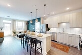 Located in Brookhaven, GA, this thoughtfully designed 2-bedroom, 2-bathroom residence offers a modern open-concept layout across a single floor. The kitchen is a standout feature, boasting light wood flat-front cabinetry, white subway tile backsplash, stainless steel appliances, and a large center island with pendant lighting and seating — ideal for both cooking and entertaining. The kitchen flows seamlessly into the living room, which is brightened by large windows and features wood-style flooring and a striking teal geometric accent wall that adds a bold, contemporary touch. The spacious primary bedroom is a serene retreat with plush carpeting, a ceiling fan, and generous natural light from oversized windows. The second bedroom is equally well-appointed with carpet, a ceiling fan, and exterior views. Both bathrooms are finished with light wood vanities, white quartz countertops, large mirrors, and wood-style flooring. Two closets, including a walk-in, provide ample storage. A private balcony extends the living space outdoors, while recessed lighting and clean white walls maintain a bright, cohesive aesthetic throughout the entire residence.