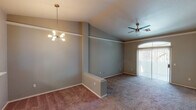 Located at 5102 E Piedmont Rd in Phoenix, AZ, this single-story home offers a thoughtfully designed layout with a blend of comfort and functionality. The open living and dining area is defined by dramatic vaulted ceilings that lend a sense of spaciousness, complemented by a stylish sputnik chandelier and a ceiling fan. Neutral-toned carpet flows throughout the living spaces, and an arched sliding glass door invites natural light while providing outdoor access. A low partition wall elegantly separates the dining and living zones.

The kitchen is well-appointed with white cabinetry, marble-look countertops, wood-look flooring, and black appliances including a refrigerator, range, built-in microwave, and a stainless steel sink — all accessible via a convenient pass-through counter open to the living area.

The bedrooms are carpeted and each features a ceiling fan. One bedroom enjoys a bright window with a view of mature trees, while another benefits from direct access to the bathroom, which includes a walk-in closet. The bathrooms are clean and functional, with one featuring a full tub-shower combo with small windows above for natural light, and another with a vanity, mirror, and wood-look flooring.