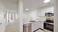 Located at 3401 Bremer Hall Ct in Raleigh, NC, this well-appointed one-bedroom, one-bathroom residence offers a thoughtfully designed single-floor layout with a clean, neutral palette throughout. The open-concept kitchen and living area serves as the heart of the home, where the kitchen impresses with granite countertops, crisp white cabinetry, stainless steel appliances including a dishwasher, range, microwave, and refrigerator, and a peninsula that connects seamlessly to the carpeted living space. Recessed lighting illuminates the kitchen, while the living area benefits from natural light streaming through a large window. A French door opens directly onto a private balcony, extending the living space outdoors and offering pleasant views of surrounding greenery. The bedroom is a comfortable retreat featuring plush carpet, a ceiling fan, and a window that brings in natural light. A dedicated closet provides organized storage. The bathroom is clean and functional, equipped with a full soaking tub and shower combination with brushed nickel fixtures and safety bars. Wood-look flooring in the kitchen and bath areas complements the soft carpet found throughout the living and sleeping spaces, creating a warm and cohesive ambiance.