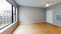 Located at 500 W Lake St in Minneapolis, MN, this efficiently designed studio offers a thoughtful layout across a single floor. The combined kitchen and living area forms the heart of the space, featuring light hardwood flooring, neutral gray walls, and large windows that invite natural light and urban views of the surrounding cityscape. The galley-style kitchen is well-appointed with white shaker cabinetry accented by matte black hardware, white quartz countertops, a classic subway tile backsplash, and a full suite of stainless steel appliances including an electric range, over-the-range microwave, refrigerator, and dishwasher. A ceiling fan overhead adds comfort to the open living area. The bathroom features large-format dark slate-style tile flooring, a walk-in shower with white surround, and a vanity with a mirrored cabinet. Two closets provide practical storage solutions, while a dedicated in-unit laundry adds everyday convenience. The clean, contemporary aesthetic is carried consistently throughout, making this a functional and modern urban residence in the heart of Minneapolis.