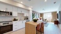 Located at 25440 Solaris Pl in Murrieta, CA, this thoughtfully designed 2-bedroom, 1-bathroom home offers a cohesive blend of modern aesthetics and functional living across a single floor. The open-concept kitchen and living area serves as the heart of the home, featuring a sleek kitchen outfitted with white flat-panel cabinetry, matte black hardware, a geometric tile backsplash, stainless steel appliances including a French door refrigerator, range, microwave, and dishwasher, and a butcher block island with bar seating. Light wood-style flooring flows throughout, enhancing the bright, airy atmosphere. The living room is a warm, inviting space accented by a terracotta feature wall, large windows that draw in natural light and outdoor views, and soft carpeting underfoot. Both bedrooms offer a cozy retreat, with the primary bedroom highlighted by a bold red accent wall and garden views through a generously sized window. The full bathroom features a clean white vanity, tub-shower combination, and warm accent walls. A hallway with wood flooring connects the private areas of the home, which also includes a dedicated closet for added storage.