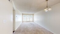 This one-bedroom, one-bathroom unit in Memphis, TN offers a practical and comfortable layout across a single floor. The living room is bright and open, featuring plush carpeting, neutral walls, a textured ceiling, and a large multi-pane window that draws in generous natural light and views of the surrounding area. A pendant light fixture adds a decorative touch overhead.

The kitchen is thoughtfully designed with warm oak cabinetry, granite-look countertops, a gas range, a full-size refrigerator, and a sink with ample counter space. Rich hardwood-style flooring anchors the kitchen and adds a contrasting warmth to the space.

The bedroom is a comfortable, well-proportioned room with soft carpeting, a window offering outdoor views, and a closet for storage. Neutral tones throughout keep the space feeling airy and open.

The bathroom is clean and functional, featuring classic white hexagonal tile flooring, a full tub-shower combination with white mosaic tile surround, a toilet, and a vanity with oak cabinetry, a light countertop, and a large wall mirror illuminated by overhead lighting.

Overall, the unit presents a cohesive, neutral palette with a mix of carpet and hardwood-style flooring, making it a functional and inviting home in Memphis.