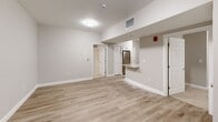 This thoughtfully designed two-bedroom, two-bathroom residence in Bedford, NH offers a clean, modern aesthetic throughout its single-floor layout. The open living area features light wood-look flooring and neutral tones that create a bright, welcoming atmosphere, with windows offering views of the surrounding wooded landscape.

The kitchen is well-appointed with white shaker cabinetry, granite countertops, stainless steel appliances including a refrigerator, range, microwave, and dishwasher, and light wood-look flooring that continues seamlessly from the living area. A breakfast bar provides additional prep and dining space.

Both bedrooms are finished with plush wall-to-wall carpeting and neutral walls, offering a comfortable retreat. The primary bedroom includes multiple windows that bring in natural light and peaceful wooded views. The second bedroom features a closet with double doors, providing ample storage.

The two bathrooms are identically finished with white vanities, granite countertops, brushed nickel fixtures, and walk-in showers equipped with accessibility grab bars — a practical and thoughtful design detail. Tile flooring completes each bathroom's clean, contemporary look.

Overall, this residence combines functional design with modern finishes, creating a comfortable and accessible living environment in Bedford, NH.