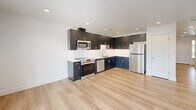 Located in Richland, WA, this two-story home offers a thoughtfully designed layout across two floors, accommodating three bedrooms and three bathrooms. The main floor is highlighted by an open-concept living area featuring light hardwood-style flooring, recessed lighting, and a sliding glass door that invites natural light and outdoor views. The kitchen is a standout space, showcasing dark cabinetry paired with a crisp white countertop and backsplash, complemented by stainless steel appliances including a range, microwave, and dishwasher. The attached garage provides convenient parking and includes an electrical panel and automatic door opener. Upstairs, three carpeted bedrooms offer comfortable, private retreats, each with windows that bring in natural light and neighborhood views. The generously sized primary bedroom provides ample space for a full suite setup. The three bathrooms are finished in clean, bright white tones, each featuring tub-shower combinations with brushed nickel fixtures. A hallway and closet add to the home's practical storage and circulation. Throughout, the home maintains a clean, modern aesthetic with neutral tones and consistent finishes.