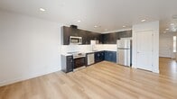 Located in Richland, WA, this two-story home offers a thoughtfully designed layout across two floors, accommodating three bedrooms and three bathrooms. The main floor is highlighted by an open-concept living area featuring light hardwood-style flooring, recessed lighting, and a sliding glass door that invites natural light and outdoor views. The kitchen is a standout space, showcasing dark cabinetry paired with a crisp white countertop and backsplash, complemented by stainless steel appliances including a range, microwave, and dishwasher. The attached garage provides convenient parking and includes an electrical panel and automatic door opener. Upstairs, three carpeted bedrooms offer comfortable, private retreats, each with windows that bring in natural light and neighborhood views. The generously sized primary bedroom provides ample space for a full suite setup. The three bathrooms are finished in clean, bright white tones, each featuring tub-shower combinations with brushed nickel fixtures. A hallway and closet add to the home's practical storage and circulation. Throughout, the home maintains a clean, modern aesthetic with neutral tones and consistent finishes.