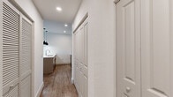 Located at 10550 SW Innovation Way in Port St. Lucie, Florida, this single-floor residence offers a contemporary design with clean lines and modern finishes throughout. Wood-look flooring runs consistently across the living areas, bedrooms, and hallways, creating a cohesive and warm aesthetic.

The open-concept kitchen serves as a central focal point, featuring light wood cabinetry, a white quartz island with an integrated sink, stainless steel appliances including a refrigerator, range, and microwave, and a white tile backsplash. Three striking black pendant lights hang above the island, adding a bold design contrast. Ample storage is provided by a tall pantry closet adjacent to the kitchen.

The living area is generously proportioned and connects seamlessly to a private balcony through sliding glass doors, allowing natural light to fill the space. A ceiling fan overhead adds comfort and function.

Bedrooms are well-sized, each equipped with ceiling fans and closets featuring built-in rods and shelving. The hallway includes additional storage with panel-style closet doors and recessed lighting overhead.

The bathroom features wood-look flooring, a vanity with light wood cabinetry, and clean white walls, maintaining the unit's modern, neutral palette throughout.