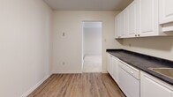Located on the 14th floor at 310 Dundas St in downtown London, Ontario, this one-bedroom, one-bathroom unit offers a thoughtfully designed layout across a comfortable single floor. The entry hallway, finished with wood-look tile flooring, leads into the main living areas and features a sliding-door closet for convenient storage.

The spacious living room is bright and airy, with plush carpeting and a sliding glass door that opens onto a private balcony with outdoor views. A pendant light fixture anchors the adjacent dining area, which flows naturally into the kitchen. The kitchen is equipped with white cabinetry, dark countertops, white appliances including a refrigerator and stove, and durable wood-look vinyl flooring throughout.

The generously sized primary bedroom offers soft carpeting, a large sliding-door closet, and a window that brings in natural light. The full bathroom features a tiled tub-and-shower combination, a white vanity with storage, and wood-look flooring that ties the space together cleanly.

Additional highlights include a dedicated laundry area and two closets, providing ample storage. The unit's neutral palette and functional floor plan make it a practical and comfortable space in the heart of London's urban core.