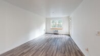 Located at 1323 SW Cherry Park Rd in Troutdale, Oregon, this well-appointed one-bedroom, one-bathroom unit offers a thoughtfully designed single-floor layout. The open-concept living, dining, and kitchen area forms the heart of the unit, featuring durable wood-look flooring throughout and crisp white walls that maximize brightness. A large window in the living area frames views of mature greenery outside, while a wall-mounted HVAC unit ensures year-round comfort. The kitchen is efficiently designed with light maple cabinetry, white countertops, and a full suite of stainless steel appliances including a refrigerator, electric range, and dishwasher. A dedicated entry area provides a practical transition space upon arrival. The bedroom offers a comfortable footprint with recessed lighting and direct access to a walk-in closet equipped with wire shelving for organized storage. The hallway connects all areas seamlessly, leading to the full bathroom, which features a glass-enclosed shower and a clean, functional layout. A private patio extends the living space outdoors. Wood-look flooring flows consistently throughout the unit, contributing to a cohesive and modern aesthetic.