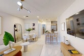 Located at 624 NE Second St in Dania Beach, FL, this thoughtfully designed one-bedroom, one-bathroom residence offers a clean, modern aesthetic throughout. The open-concept living, dining, and kitchen area is anchored by large-format white tile flooring that reflects natural light streaming in through windows dressed with sheer curtains. A contemporary ceiling fan with a gold-toned fixture adds a stylish accent overhead, while recessed lighting ensures the space is well-illuminated.

The kitchen is equipped with stainless steel appliances, including a French door refrigerator, range, and over-the-range microwave. Taupe cabinetry pairs with granite countertops to deliver both function and style, complemented by a peninsula with bar seating that connects the kitchen to the living and dining areas.

The bedroom is a calm retreat featuring plush carpeting, a striking gold chandelier, and a window with outdoor greenery views, allowing ample natural light. A dedicated closet provides convenient storage.

The bathroom includes a granite-topped vanity with cabinetry, a shower-tub combination, and tile flooring. A stacked washer and dryer unit is conveniently situated adjacent to the bathroom. The overall palette of warm whites and natural wood tones creates a cohesive, inviting ambiance throughout the residence.