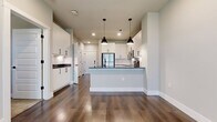 This 540 sq ft, 1-bedroom, 1-bathroom unit at 4177 Gazebo Street in Aubrey, TX offers a well-designed, modern living space. The open-concept kitchen and living area features wood-look flooring, white shaker cabinets with black hardware, dark granite countertops, a subway tile backsplash, stainless steel appliances, and a peninsula island. The 110 sq ft bedroom includes plush carpet, a ceiling fan, and multiple windows for natural light. The bathroom offers white cabinetry with granite counters and direct access to a dedicated walk-in closet with built-in shelving.
