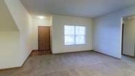 Located at 51 Great Trail Cir in Pickerington, Ohio, this single-floor residence offers a clean and functional layout designed for comfortable everyday living. The interior is finished with neutral, light-toned walls throughout, creating a bright and welcoming atmosphere that feels open and easy to personalize.

The living area is carpeted and generously sized, providing a comfortable space for relaxation and gathering. A large multi-pane window allows natural light to flow freely into the room, enhancing the sense of openness. The entryway features a wood-toned door with an adjacent utility closet, offering practical storage from the moment you step inside. The transition between the tiled entryway and the carpeted living space is a subtle but functional design detail.

The overall ambiance of the unit is understated and move-in ready, with clean lines and a straightforward layout that suits a variety of living arrangements. The light color palette and neutral finishes throughout contribute to a calm, versatile interior that can be easily adapted to different styles and furnishings. This single-level layout ensures easy accessibility and convenience, with all living spaces located on one floor.