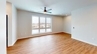This contemporary 530 square foot apartment in New London showcases an efficient and stylish design. The open-concept layout maximizes space, seamlessly blending the kitchen and living areas. The kitchen boasts modern appliances, light wood cabinetry, and a sleek white subway tile backsplash. Stainless steel appliances, including a built-in microwave and range, complement the overall aesthetic.

Throughout the apartment, warm wood-look flooring creates a cohesive and inviting atmosphere. Recessed lighting and a ceiling fan provide both ambiance and functionality. Large windows in the living area flood the space with natural light and offer expansive city views, enhancing the sense of openness.

The bathroom features a clean, modern design with a vanity and standard fixtures. A separate laundry area with built-in shelving adds convenience. The apartment's neutral color palette, predominantly whites and light woods, contributes to a bright and airy feel throughout.

This compact yet well-designed space efficiently incorporates all essential living areas, making it an ideal urban dwelling for those seeking a modern, low-maintenance lifestyle in the heart of New London.