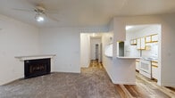 Located at 3613 Pine Lake Dr in Fayetteville, NC, this single-floor residence offers a well-organized layout designed for comfortable everyday living. The open-concept living area serves as the heart of the home, highlighted by a classic fireplace with a white mantle, a ceiling fan overhead, and plush carpeting underfoot. A smooth transition connects this space to the kitchen, which features a raised breakfast bar, white appliances including an electric range and refrigerator, wood-trimmed cabinetry, and wood-look plank flooring that extends throughout the common areas. The bedrooms are carpeted and bright, each receiving natural light through windows fitted with blinds. One bedroom includes access to a walk-in closet, offering practical storage. The bathrooms are finished in a clean, neutral palette with wood-look tile flooring, vanities with ample counter space, and full tub-shower combinations. A covered porch area, visible in the floorplan, provides an outdoor retreat. Throughout the residence, white walls and consistent finishes create a cohesive, clean aesthetic that is both functional and move-in ready.