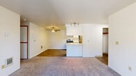 This efficiently designed one-bedroom, one-bathroom unit offers a well-organized layout across a single floor, making practical use of its compact footprint. The open-concept living area features plush carpet flooring and a sliding glass door that fills the space with natural light while providing views of the surrounding neighborhood. A ceiling fan overhead adds both function and comfort to the living space.

The kitchen is positioned adjacent to the living area, separated by a peninsula-style counter that creates a natural division while maintaining an open feel. White cabinetry lines the kitchen walls, complemented by stainless steel appliances including an electric range and refrigerator, wood-look flooring, and a range hood overhead. A track light fixture provides dedicated task lighting.

The bedroom is a comfortable, carpeted room featuring a sliding wood-framed closet with built-in shelving for organized storage. The bedroom also benefits from a sliding glass door, allowing additional natural light and outdoor access.

The bathroom is finished with wood-look tile flooring, a white vanity with light countertops, and a full tub-shower combination enclosed by sliding frosted-glass doors, lending a clean, updated aesthetic throughout.