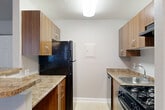 Located at 1002 Kennebec St in Oxon Hill, MD, this one-bedroom, one-bathroom residence offers a practical and comfortable layout across a single floor. The combined dining and living area is bright and inviting, featuring soft carpet flooring, neutral gray walls, a textured ceiling, and a ceiling fan with light fixture. Two generously sized windows flood the space with natural light, creating an open and airy atmosphere. A breakfast bar separates the living area from the galley-style kitchen, which is outfitted with warm wood-tone cabinetry, granite-look countertops, tile flooring, and black appliances including a gas range, refrigerator, and dishwasher. The entrance area provides a welcoming foyer with closet storage nearby. The spacious bedroom features plush carpeting, a large window for natural light, and a sliding double-door closet offering ample storage. Additional closet space is found throughout the unit, with a total of five closets providing exceptional storage capacity. The full bathroom is clean and functional, featuring tile flooring, a single vanity with wood cabinetry, a large mirror, and a tiled shower-tub combination. The overall ambiance is clean, neutral, and move-in ready.