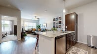 Located on Sheffield Place in Wichita, KS, this well-appointed one-bedroom, one-bathroom unit offers a thoughtfully designed open-concept layout. The kitchen is a standout feature, boasting rich dark-wood cabinetry, granite countertops, a large peninsula with seating for multiple bar stools, pendant lighting, and a full suite of stainless steel appliances including a refrigerator, electric range, microwave, and dishwasher. The kitchen flows seamlessly into a bright and airy living room finished with wood-style plank flooring, a ceiling fan, and large windows that invite generous natural light. The bedroom is a comfortable retreat with plush carpeting, a ceiling fan, ample natural light from a large window, and access to a dedicated closet. The bathroom continues the granite and dark-wood cabinetry theme, maintaining a cohesive design throughout the unit. A dedicated in-unit laundry area houses a full-size washer and dryer, adding everyday convenience. The neutral color palette and consistent finishes create a modern, cohesive aesthetic that carries throughout the entire space.