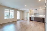 This well-appointed one-bedroom, one-bathroom residence at 3461 La Cadena Dr in Riverside, California offers a thoughtfully designed open-concept layout that seamlessly connects the living, dining, and kitchen areas. Light wood-tone flooring flows throughout the main living spaces, complemented by recessed lighting and large windows fitted with blinds that fill the room with natural light.

The contemporary kitchen is a standout feature, equipped with a full suite of stainless steel appliances including a French door refrigerator, gas range, over-the-range microwave, and dishwasher. Two-tone cabinetry pairs white upper cabinets with warm wood-grain lower cabinets, while a striking marble-style tile backsplash adds a refined touch. A private balcony extends the living space outdoors.

The bedroom is carpeted for comfort and includes access to a generously sized walk-in closet with wire shelving systems for ample storage. The bathroom features a full tub-shower combination with subway tile surround and light wood-tone flooring. A dedicated laundry area and additional closet spaces add to the unit's practicality. The clean, neutral color palette throughout creates a bright, modern ambiance.