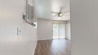Located at 1535 NW Fifth Ave in Gainesville, FL, this efficient one-bedroom, one-bathroom unit offers a practical and well-organized layout across a single floor. The living room is bright and open, featuring dark hardwood-style flooring, a ceiling fan with light fixture, a wall-mounted AC unit, and a sliding glass door fitted with vertical blinds that invites natural light and provides outdoor access. A separate window along the side wall adds additional ventilation and brightness to the space.

The kitchen is a functional galley-style space equipped with warm wood cabinetry, a gas range, a double-basin sink, and a refrigerator — offering ample storage for everyday needs.

The bedroom is carpeted for comfort and receives generous natural light through a large window with vertical blinds. It connects directly to a dedicated walk-in closet complete with built-in shelving, providing practical storage solutions.

The bathroom features tile wainscoting, a warm wood vanity with under-sink storage, a medicine cabinet mirror, and hardwood-style flooring, maintaining a clean and functional aesthetic consistent with the rest of the unit. Throughout the space, neutral wall tones and consistent flooring materials create a cohesive and easy-to-personalize environment.