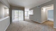 Located at 15100 Ella Blvd in Houston, TX, this two-story home offers a functional and comfortable layout spread across two levels. The ground floor is anchored by a generously sized attached garage with a concrete floor, automatic door opener, and direct interior access — providing ample space for parking and storage. The main living areas are situated on the upper floor, where the layout opens up considerably. The living room is a bright, open space featuring plush carpeting, large sliding glass doors with vertical blinds that invite natural light, and a pass-through connection to the kitchen. The kitchen is well-appointed with white cabinetry accented by wood trim, granite-look countertops, a stainless steel sink, and white appliances including a range and over-the-range microwave, all set atop durable wood-look flooring. The three bedrooms are carpeted and filled with natural light through large windows with outdoor views of surrounding trees. Ceiling fans are featured in the bedrooms, and the spacious primary bedroom includes a dedicated closet and direct bathroom access. The full bathroom offers a wide granite-look vanity with ample cabinet storage, wood-look flooring, a large mirror, and a tiled shower-tub combination. Hallways connect the rooms seamlessly throughout the upper floor.