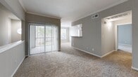 Located at 15100 Ella Blvd in Houston, TX, this two-story home offers a functional and comfortable layout spread across two levels. The ground floor is anchored by a generously sized attached garage with a concrete floor, automatic door opener, and direct interior access — providing ample space for parking and storage. The main living areas are situated on the upper floor, where the layout opens up considerably. The living room is a bright, open space featuring plush carpeting, large sliding glass doors with vertical blinds that invite natural light, and a pass-through connection to the kitchen. The kitchen is well-appointed with white cabinetry accented by wood trim, granite-look countertops, a stainless steel sink, and white appliances including a range and over-the-range microwave, all set atop durable wood-look flooring. The three bedrooms are carpeted and filled with natural light through large windows with outdoor views of surrounding trees. Ceiling fans are featured in the bedrooms, and the spacious primary bedroom includes a dedicated closet and direct bathroom access. The full bathroom offers a wide granite-look vanity with ample cabinet storage, wood-look flooring, a large mirror, and a tiled shower-tub combination. Hallways connect the rooms seamlessly throughout the upper floor.