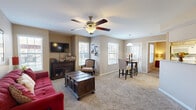 This thoughtfully designed 2-bedroom, 2-bathroom single-floor home offers a comfortable and functional layout across a well-utilized footprint. The open-concept main living area seamlessly integrates the living room, dining room, and kitchen, creating a cohesive and inviting space. The living room features plush carpeting, a ceiling fan, and multiple windows that allow natural light to fill the room. The galley-style kitchen is equipped with granite countertops, light wood cabinetry, a double sink, and white appliances, with direct access to a dedicated in-unit laundry room. The dining area sits adjacent to the kitchen, accented by a pendant light fixture.

Both bedrooms are carpeted and include ceiling fans. The primary bedroom offers a comfortable sense of space, a window with natural light, and access to a walk-in closet outfitted with wire shelving. The second bedroom also includes closet storage. Each of the two full bathrooms features a tiled shower-tub combination with a distinctive diamond-pattern tile accent, granite-topped vanities with light wood cabinetry, and wood-look flooring. A connecting hallway ties the rooms together efficiently. The warm, neutral color palette throughout lends the home a cohesive and welcoming ambiance.