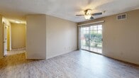 Located at 619 Orlando Ave in Normal, IL, this single-floor unit offers three bedrooms and two full bathrooms in a thoughtfully laid-out floor plan. The living area serves as the heart of the home, featuring light wood-style flooring, a ceiling fan with light fixture, and a sliding glass door that fills the space with natural light and provides access to the outdoors. The kitchen is equipped with white appliances including a range and refrigerator, a peninsula with an undermount sink, white cabinetry, and matching wood-style flooring that flows seamlessly from the main living area. Both bathrooms feature wood-style flooring, vanities with storage, and full bathtub/shower combinations. The primary bedroom offers a dedicated hallway with closet storage on both sides leading to its en-suite bathroom, providing added privacy. All three bedrooms are carpeted and receive natural light through blinds-equipped windows. The textured ceilings are consistent throughout, contributing to a cohesive aesthetic. Neutral warm beige tones across walls and finishes create a clean, move-in ready environment throughout the entire unit.