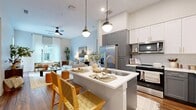 This contemporary 940 square foot apartment in Austin, TX, showcases a thoughtful blend of style and functionality. The open-concept layout seamlessly integrates the kitchen, living, and dining areas, creating a spacious feel. The gourmet kitchen features a mix of white and gray cabinetry, stainless steel appliances, and a central island with seating, perfect for casual dining or entertaining.

The living room is bathed in natural light from large windows and offers access to a private balcony. Comfortable seating and carefully curated decor create a welcoming atmosphere. Both bedrooms are generously sized, with the primary bedroom measuring 130 square feet. They feature plush carpeting, ample closet space, and large windows.

The two full bathrooms boast modern fixtures, sleek vanities, and glass-enclosed showers. Throughout the apartment, warm hardwood floors contrast beautifully with the crisp white walls, creating a fresh and inviting ambiance. Thoughtful touches like pendant lighting, stylish mirrors, and greenery add character to the space.

This apartment combines contemporary design with practical living, offering a perfect urban retreat in the heart of Austin.