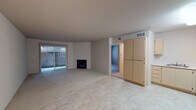 This single-story residence at 52 Pheasant Ct in Pittsburg, California offers a straightforward, functional layout designed for comfortable everyday living. The main living area is generously proportioned, featuring a combination of tile flooring and carpet, and is anchored by a fireplace that serves as a central focal point. Vertical blinds frame a sliding glass door that opens to a private patio, allowing natural light to filter into the space and providing a seamless connection to the outdoors.

The kitchen is efficiently designed in an L-shaped configuration, equipped with light wood cabinetry offering ample storage, white appliances including an electric range, built-in microwave, dishwasher, and refrigerator, as well as light-toned countertops. Tile flooring extends throughout this area, transitioning to carpet in the adjoining spaces. The front entry area sits adjacent to the kitchen, providing a practical and accessible entrance.

The bedroom features carpeted flooring and a window with blinds that brings in natural light and outdoor views. The bathroom includes a tub and shower combination enclosed by sliding glass doors, a single-sink vanity with light wood cabinetry, and a well-lit mirror. Additional practical features include an electrical panel and interior storage areas accessible via hallway doors.