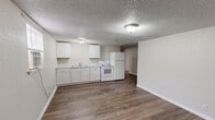 Located at 3304 W Hwy 80 in Big Spring, Texas, this single-story 2-bedroom, 1-bathroom home offers a straightforward and functional layout designed for comfortable everyday living. Wood-look flooring runs consistently throughout the home, providing a cohesive and easy-to-maintain surface in every room.

The open kitchen and living area form the heart of the home. The kitchen features white cabinetry, a double-basin sink, a white electric range, and a full-size refrigerator, all set against neutral walls with textured ceilings. The adjacent living space offers an open, flexible area that flows naturally toward a hallway leading to the rest of the home.

Both bedrooms are well-proportioned and include ceiling fans with light fixtures for added comfort and ventilation. Each bedroom features a window that brings in natural light, along with dedicated closet space. The primary bedroom is notably spacious, offering ample room for furnishings.

The bathroom is appointed with a tub and shower combination featuring elegant marble-look wall surrounds with chrome fixtures, adding a clean and polished touch to the space. Textured ceilings are present throughout the home, and neutral-toned walls provide a versatile backdrop throughout. A hallway connects the main living areas to the bedrooms and bathroom, keeping the floor plan organized and efficient.
