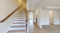 Located at 2978 Cedarcrest Rd in Acworth, GA, this two-story home offers five bedrooms and four bathrooms thoughtfully arranged across two floors. The main level features light hardwood-style flooring throughout, an open-concept kitchen and living area, and a dedicated living room. The kitchen is equipped with dark espresso cabinetry, granite countertops, stainless steel appliances, a subway tile backsplash, and a central island, making it both functional and stylish. A graceful staircase with wood-toned treads, white risers, and a classic newel post connects the floors, highlighted by crown molding and recessed lighting in the entryway. One of the main-level rooms features a tray ceiling and elegant chandelier, adding architectural distinction. The bathrooms feature dark vanity cabinetry with granite countertops and round mirrors. Bedrooms on the upper level are carpeted for comfort, with neutral tones and natural light from double-hung windows. The generously sized primary bedroom offers a walk-in closet with wire shelving. Additional closets provide ample storage throughout. The home's clean, neutral palette and consistent use of quality finishes create a cohesive, move-in-ready feel suited for modern living.