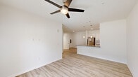 This well-appointed 1-bedroom, 1-bathroom unit in Denham Springs, Louisiana offers a bright and modern living experience across a single thoughtfully designed floor. Light wood-style plank flooring runs seamlessly throughout, complementing the crisp white walls and clean-lined architectural details that give the space a fresh, contemporary feel.

The open-concept living area is anchored by a ceiling fan with light fixture and flows naturally into the kitchen. French doors in the living room invite natural light and provide outdoor views, enhancing the sense of openness. The kitchen features white shaker-style cabinetry, granite countertops, a peninsula with pendant lighting and a built-in sink, and stainless steel appliances including a refrigerator, range, and microwave.

The bedroom is a comfortable and naturally lit retreat, with two windows fitted with blinds and its own ceiling fan. A dedicated closet offers practical storage, and the room connects conveniently to the bathroom.

The bathroom is finished with the same light flooring and includes a glass-enclosed walk-in shower with clean white surrounds. A hallway with recessed lighting connects all areas of the unit, with a dedicated closet providing additional storage. The overall ambiance is bright, clean, and move-in ready.