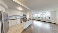 Located at 65 Forest Manor Rd in Toronto's north end, this well-appointed 3-bedroom, 1-bathroom unit offers a generous and functional layout across a single floor. The modern kitchen is a standout feature, fitted with stainless steel appliances including a full-size refrigerator, electric range, and built-in microwave. White shaker cabinetry, a subway tile backsplash, dark countertops, and a central island provide ample storage and prep space, while light tile flooring ties the look together cleanly.

The open living room is bathed in natural light from large windows overlooking the surrounding neighbourhood, and features classic parquet wood flooring that carries throughout all three bedrooms. Each bedroom is generously proportioned — the primary bedroom is notably spacious — and benefits from large windows with urban views and baseboard heating. Mirrored sliding closet doors in the primary bedroom add both storage and a sense of depth.

The bathroom is finished with crisp white subway tile surrounding a full soaker tub and shower combination, maintaining a clean and timeless aesthetic. A connecting hallway links all rooms efficiently. The overall ambiance is bright, neutral, and move-in ready, offering a comfortable urban living experience in a well-established Toronto location.