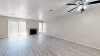 Located in Albuquerque, NM, this two-story, 3-bedroom, 2-bathroom home offers a practical and comfortable layout spread across two floors. The main level features an open living area with light wood-style flooring, a ceiling fan, a fireplace flanked by windows, and sliding door access to the outdoors. The kitchen is well-appointed with white shaker cabinetry, light countertops, stainless steel appliances including a range, dishwasher, and refrigerator, plus a built-in pantry with open shelving and a natural light window. An additional open room on the main floor, also with wood-style flooring, offers flexible use and connects to the staircase. Upstairs, the three bedrooms are carpeted and feature closets with sliding doors and windows that bring in natural light. The spacious primary bedroom includes a generously sized closet. Both bathrooms are finished with wood-style tile flooring, white vanity cabinetry, bright mirrors, and tub/shower combinations. Textured ceilings are present throughout, adding a classic touch. The neutral color palette and clean finishes create a bright, move-in ready atmosphere throughout the home.