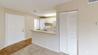 Located at 4550 47th St W in Bradenton, Florida, this single-floor residence offers a practical and comfortable layout across a generously sized living area. The interior features warm neutral tones, soft carpeting in the living and bedroom areas, and tile flooring in the kitchen, creating a cohesive and inviting atmosphere throughout.

The kitchen is efficiently designed with white cabinetry providing ample storage, a full suite of white appliances including a range, overhead microwave, and refrigerator, and a peninsula countertop with a double-basin sink. The peninsula opens toward the living area, creating a connected, open feel between the kitchen and main living space. A set of louvered closet doors near the entry adds additional storage convenience.

The spacious bedroom offers a generous footprint, neutral carpeting, and a ceiling fan with light fixture, ensuring comfort year-round. A window brings in natural light and frames views of the surrounding greenery. The bedroom also features a walk-in closet with built-in shelving, offering practical storage solutions.

The bathroom includes a full-size tub and shower combination with clean white tile surround and chrome fixtures, maintaining a bright and functional aesthetic. The textured ceilings and soft color palette throughout the unit contribute to a calm, understated ambiance well-suited to Florida living.