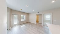 Located at 5045 Burke Road in Pasadena, TX, this thoughtfully designed 3-bedroom, 2-bathroom single-floor home offers a clean, modern aesthetic throughout. Light-toned luxury vinyl plank flooring flows through the main living areas, complemented by recessed lighting and a neutral color palette that enhances the bright, airy atmosphere.

The open-concept kitchen is a standout feature, boasting two-tone cabinetry with rich dark wood lower cabinets and crisp white uppers, light quartz countertops, a subway tile backsplash, stainless steel appliances, and a central island with a sink — ideal for both cooking and entertaining. The kitchen connects seamlessly to the combined dining and living area, which benefits from natural light and direct access to a private balcony.

The primary bedroom is a comfortable retreat with recessed lighting, a balcony door, and ample natural light through large windows. The primary bathroom features a walk-in glass-enclosed shower with marble-style tile, a double-sink vanity with modern fixtures, and wood-toned cabinetry. Additional bedrooms are carpeted with ceiling fans, windows overlooking greenery, and closet storage. Six closets total provide exceptional storage throughout. A dedicated laundry area, pantry, and hallway round out this well-appointed home.