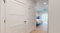 This thoughtfully designed studio offers a efficient single-floor layout that maximizes every square foot. The open-plan living and kitchen area features light hardwood-style flooring, crisp white walls, and a contemporary kitchen outfitted with dark cabinetry, subway tile backsplash, stainless steel appliances, and a convenient in-unit washer. A comfortable seating area adjoins the kitchen, making the space both functional and inviting.

The sleeping area is bright and airy, benefiting from a large sliding glass door with vertical blinds that leads to a private balcony, allowing generous natural light to fill the room. A wall-mounted mini-split air conditioning unit and a ceiling fan ensure year-round comfort. Two white panel doors provide access to dedicated storage or closet space, adding practical organization to the layout.

The bathroom is finished to a high standard, showcasing a walk-in shower enclosed by black-framed glass doors and lined with elegant gray subway tile, complemented by matte black hardware accents. Throughout the unit, recessed lighting and a clean, neutral color palette create a cohesive, modern ambiance that feels open and well-appointed despite its compact footprint.