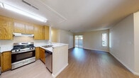 This single-floor residence offers a thoughtfully designed layout that balances openness with functional living. The heart of the home is the open-concept kitchen and living area, where warm oak cabinetry, marble-style countertops, and a full suite of stainless steel appliances — including a gas range, refrigerator, and dishwasher — define the kitchen space. A peninsula counter seamlessly connects the kitchen to the expansive living area, which features light wood-style flooring and a ceiling fan. Sliding glass doors and multiple windows invite an abundance of natural light and provide views of the outdoor surroundings. The living space flows easily into a hallway leading to the private quarters. The bedrooms are finished with plush carpeting and feature mirrored sliding closet doors offering generous storage. One bedroom benefits from direct access to a walk-in closet and an en-suite bathroom. Both bathrooms are finished with marble-style vanity countertops, oak cabinetry, and full soaking tub-shower combinations. Clean white walls and neutral tones throughout create a bright, cohesive ambiance that is both inviting and move-in ready.