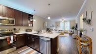 Located in Tampa's Highwoods Preserve area, this single-floor, 2-bedroom, 2-bathroom residence offers a thoughtfully designed layout with modern finishes throughout. The open-concept kitchen and living area serves as the heart of the home, featuring rich dark-espresso cabinetry, light quartz countertops, stainless steel appliances, and pendant lighting over a breakfast bar with seating. Wood-look flooring runs through the main living areas, while crown molding and a ceiling fan add a polished touch. The living room is bright and welcoming, with large windows that invite abundant natural light and views of lush greenery outside. The spacious primary bedroom features plush carpet, a ceiling fan, and generous windows, creating a comfortable and relaxing retreat. The second bedroom is equally well-sized, also carpeted, and includes a window with natural light. Both bathrooms are finished with dark vanity cabinetry, light countertops, and wood-look tile flooring, with tub-shower combinations. A dedicated in-unit laundry room accommodates a full-sized washer and dryer. The overall ambiance is warm and contemporary, with neutral tones creating a cohesive and inviting atmosphere throughout the home.