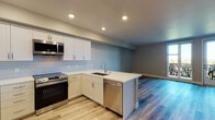 Located at 1250 Lakeside Dr in Sunnyvale, California, this modern single-floor residence offers a thoughtfully designed open-concept layout that seamlessly connects the kitchen and living areas. Light wood-tone vinyl plank flooring flows throughout, lending a clean, cohesive aesthetic to the entire space.

The kitchen is a standout feature, showcasing white shaker-style cabinetry with brushed nickel hardware, white quartz countertops, and a classic subway tile backsplash. A full suite of stainless steel appliances — including a French door refrigerator, electric range with over-the-range microwave, and dishwasher — completes the space. A peninsula with an undermount sink provides additional prep space and opens directly to the living area, enhancing the open flow.

The living area is generously proportioned, bathed in natural light, and anchored by a set of glass French doors that lead to a private balcony with outdoor views — an ideal spot to enjoy California's pleasant climate.

The bathroom is finished with a shaker-style vanity, white quartz countertop, large mirror with integrated lighting, and a full tub-shower combination with clean white tile surround. Neutral warm-gray wall tones throughout the residence create a calm, inviting ambiance that complements the modern finishes.